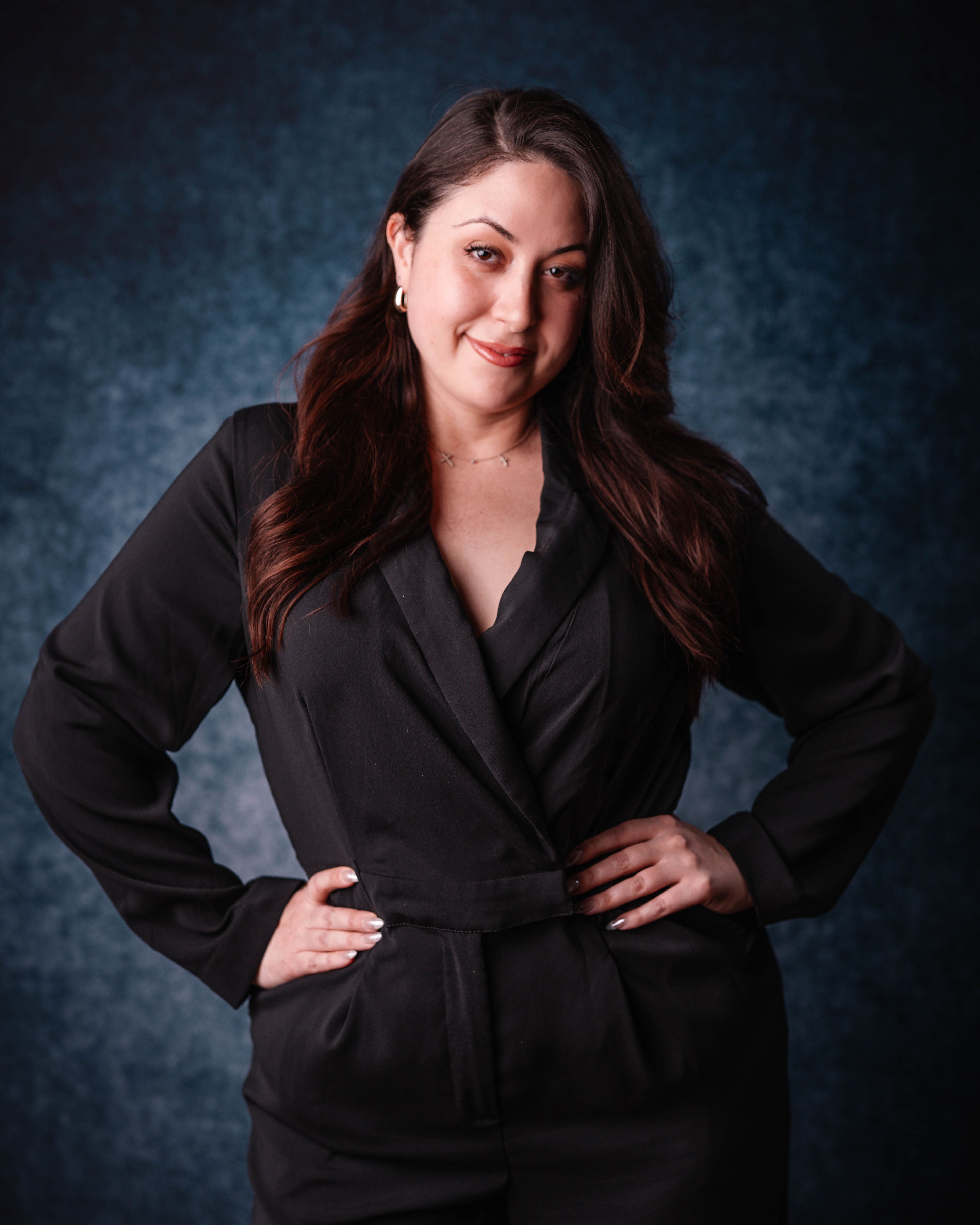 Woman wearing a black suit against a dark blue background